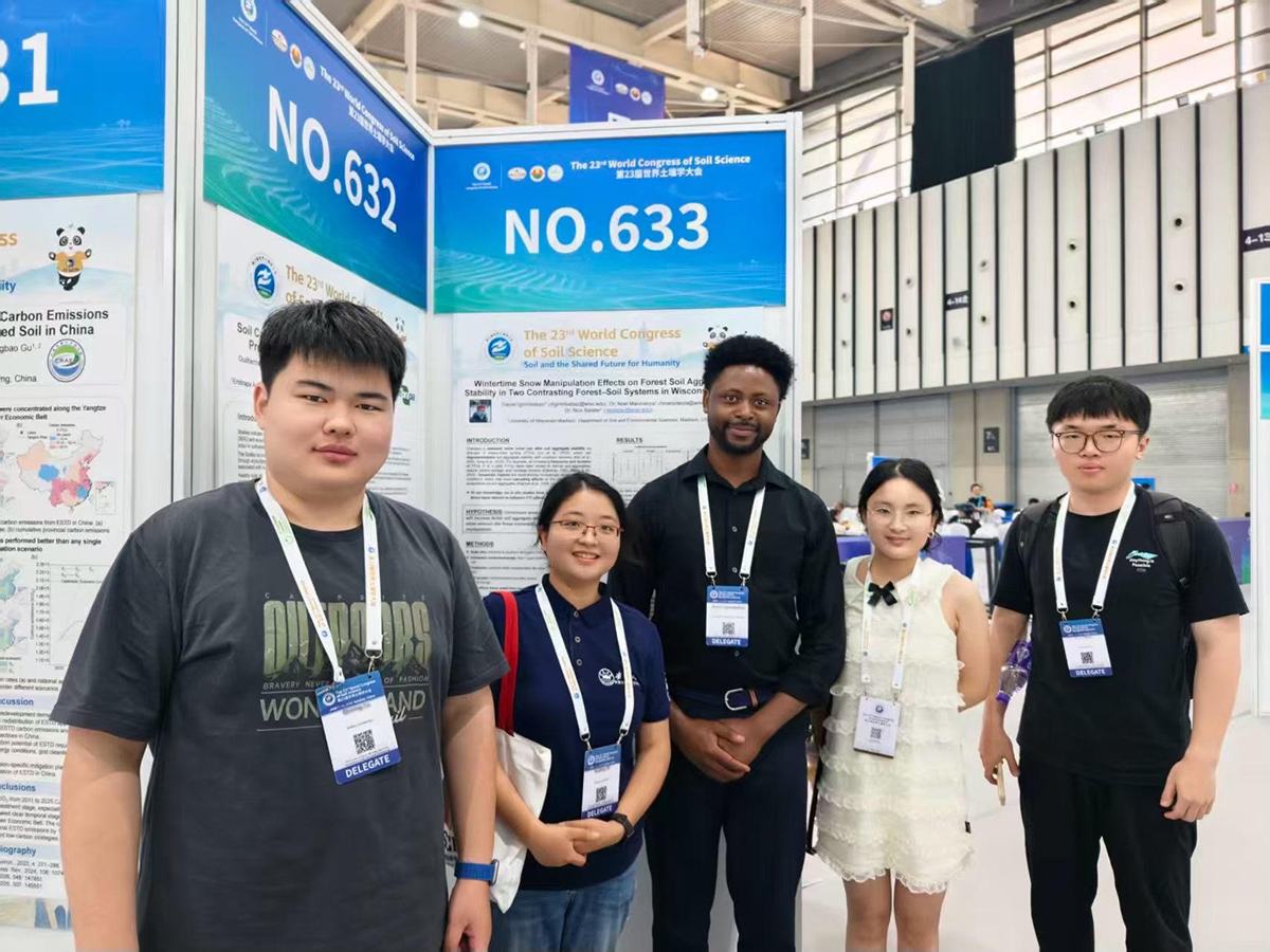 University of Wisconsin-Madison doctoral student Daniel Igirimbabazi, center, stands with international researchers in front of his research poster. Igirimbabazi shared his first season of research regarding how freeze-thaw cycles affect forest soil aggregate stability during a poster session at the conference in Nanjing, China.