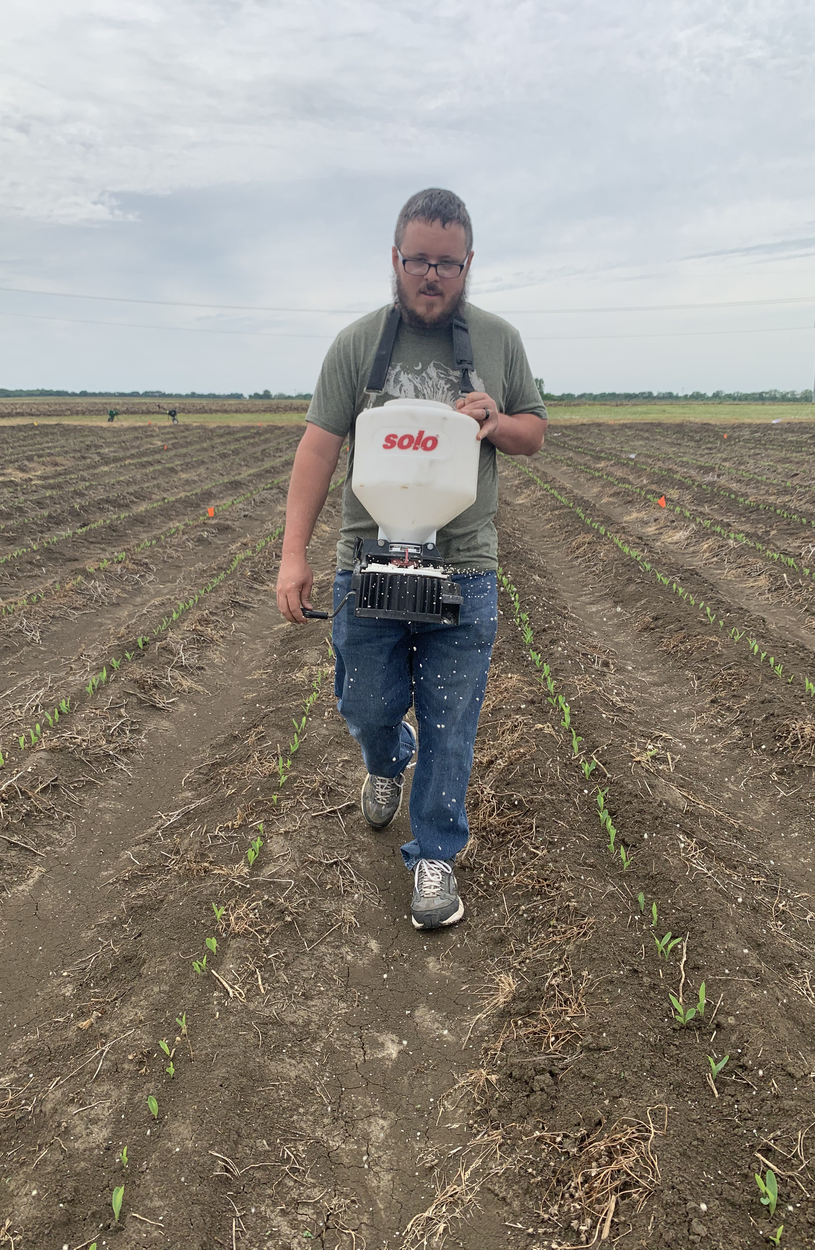 James Dew, lead author of the grain yield paper and co-author of the grain composition paper, broadcasting fertilizer.