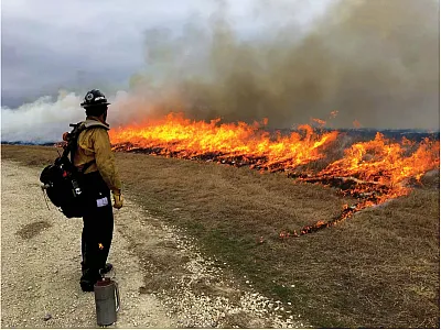 A prescribed burning crew member monitors a patch of burning rangeland. Photo courtesy of the USEPA.