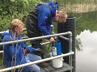 Installing in situ nutrient sensors at the outlet of the wetland-pond system in Wytham, UK. Photo by Helen Jarvie.